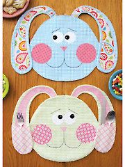 two bunny shaped placemats sitting on top of a wooden table