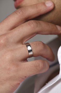 a man wearing a wedding band and an engagement ring