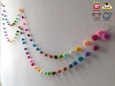 the wall is decorated with multicolored pom poms