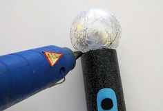 a close up of a blue and black object with a silver ball on it's end