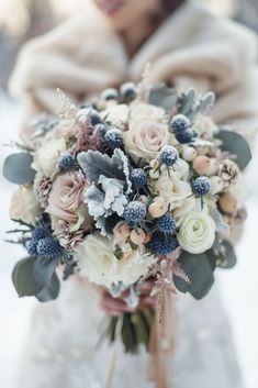 a bridal holding a wedding bouquet in the snow