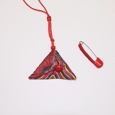 an ornament with a red string attached to it and a pair of ear buds