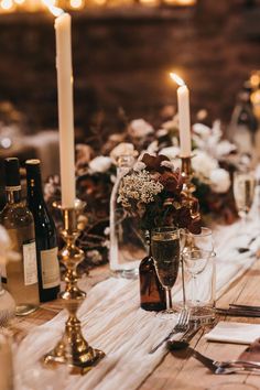 the table is set with candles and wine bottles