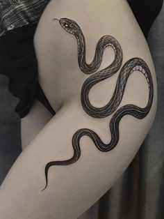 a woman's thigh with a snake tattoo on it