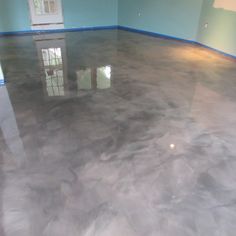 an empty room with blue walls and gray flooring is shown in the foreground