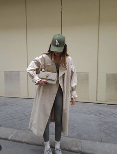 a woman in grey leggings and a trench coat