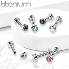 four pairs of stainless steel nose studs with colorful crystal stones on each side and an earring