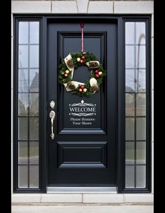 a black front door with a wreath on it