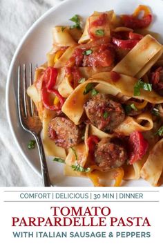 a white plate topped with pasta covered in sauce and meatballs next to a fork