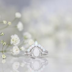 The Beautiful Dreamer ring is inspired by the 1864 song called "Beautiful Dreamer." The alternating marquise and round stone halo design is reminiscent of the graceful curves of a flower blooming. The ring has a dreamy and ethereal aesthetic, but is also classic and timeless. Ethereal Wedding Rings With Rose Cut Diamonds, White Cluster Rings With Rose Cut Diamonds, Elegant White Cluster Ring With Halo Design, White Marquise Cut Halo Design Jewelry, Elegant White Teardrop Moonstone Ring, White Flower Ring With Diamond Accents For Wedding, Ethereal Halo Wedding Jewelry, White Marquise Cluster Ring Fine Jewelry, Marquise White Sterling Silver Ring