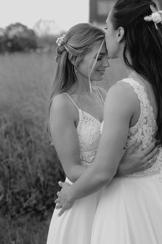 two women in wedding dresses embracing each other