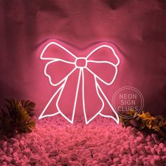 a pink neon sign with a bow on it