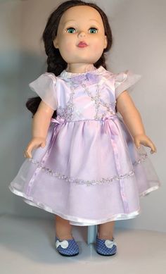 a doll wearing a purple dress and blue shoes