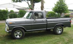 a gray truck parked on top of a lush green field