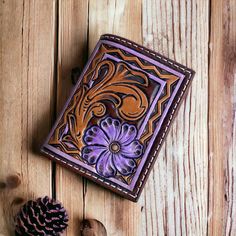 100% handmade tooled leather card holder. Card holder features one of a kind hand tooling with bright lilac purple accents, lined purple interior with 2 card holders on the inside, 1 purple exterior card pocket, and a magnetic closure. Three card pockets total. Perfect for on the go when you don't want to carry a large wallet or purse! Holder measures 3" x 4" Brown Hand Tooled Trifold Wallet As Gift, Hand Tooled Rectangular Wallet For Gift, Hand Tooled Brown Wallets As Gift, Hand Tooled Rectangular Wallet As Gift, Handmade Artisan Trifold Wallet, Artisan Hand-tooled Wallets For Everyday Use, Artisan Hand-tooled Wallets For Gifts, Artisan Hand Tooled Wallet For Everyday Use, Hand Tooled Leather Trifold Wallet As Gift