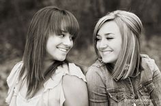 two young women sitting next to each other smiling