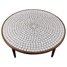 a round table with white and brown tiles on it's top, against a white background