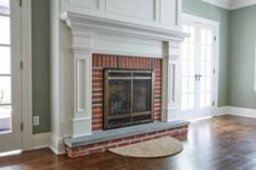 an empty living room with a fireplace and hardwood floors