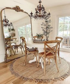 a dining room table with chairs and a chandelier hanging from the ceiling above it