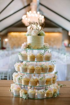 a wedding cake and cupcakes are stacked on top of each other