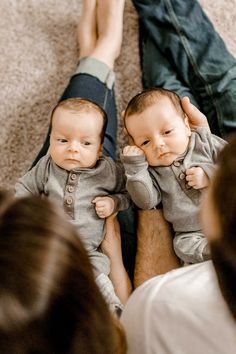 two babies are sitting on their mother's lap