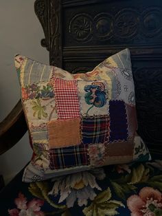 a decorative pillow with patchwork on it sitting on top of a floral print chair