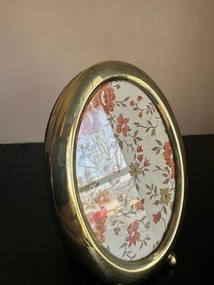 a clock with flowers on it sitting on a table