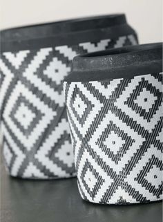 two black and white baskets sitting on top of a table