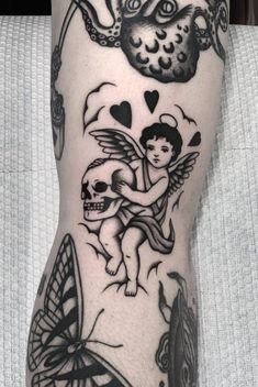 a person with tattoos on their legs holding a skull and an angel in the sky