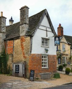 an old brick building with a clock on it's front and side windows next to a street