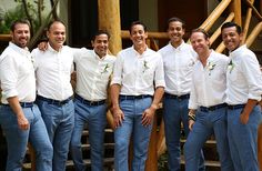 a group of men standing next to each other in front of a wooden structure and stairs