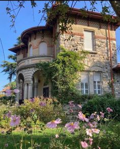 the house is surrounded by flowers and trees