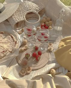 a picnic with strawberries, wine glasses and pizza