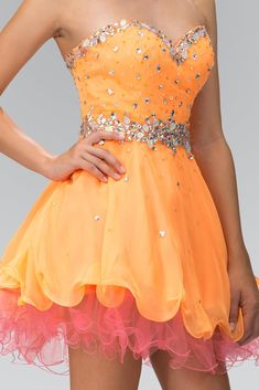 a woman in an orange and pink dress with sequins on the bustle