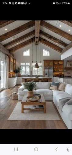 a living room filled with white furniture and wooden beams on top of a hard wood floor