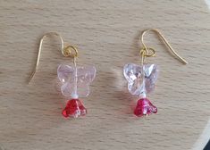 These delicate rose-colored butterfly earrings shine on your ears. The color combination with a red glass flower makes the earrings stand out. Pink Butterfly Earrings With Ear Wire, Red Butterfly Earrings For Gift, Pink Butterfly Charm Earrings As Gift, Pink Butterfly Earrings For Summer, Pink Butterfly Charm Earrings For Gift, Elegant Pink Earrings With Butterfly Charm, Pink Drop Earrings With Butterfly Charm, Pink Butterfly Charm Drop Earrings, Elegant Pink Butterfly Charm Earrings