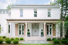 a large white house with columns and two story front porchs on either side of the door