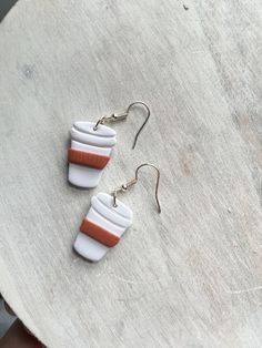 two white and orange earrings sitting on top of a table