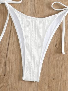 Soak up the sun in the Coco Bikini Set, where chic meets comfort in a luxurious package. This alluring white two-piece features a textured fabric with a hint of shimmer, halter neck ties for the perfect fit, and charming side-tie bottoms that offer both style and adjustability. Make a splash with its flattering ruched detailing and delicate front clasp, ensuring you're the embodiment of poolside grace. Specs: Material: Polyester White String Tie Swimwear For Beach Season, Textured Summer Beach Bottoms, White String Tie Swimwear For Pool, White Tie-side Bottom Swimwear With String Tie, Textured Tie-side Bottom Swimwear For Beach, White Tie-side Swimwear With String Tie, White String Tie Swimwear For Summer, White Triangle Top Swimwear With Drawstring, White String Tie Swimwear For Sunbathing