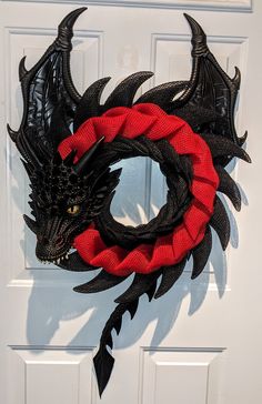 a black and red dragon wreath on a white door