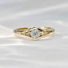 two gold wedding rings with a diamond in the center on a white background, close up