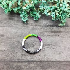 Flexible Handmade dainty thin beaded ring band with colors of Aromantic and Asexual Pride flag. Made out of high-quality Japanese glass beads. This ring is NOT stretchy. Listing is for one ring. All items are packaged as gift-ready. Packaging is discreet and does not have LGBT labeling on it. *Colors may vary slightly due to monitor differences and lighting nature* Handmade in the USA.  Please make sure that your address on file with Etsy is correct. Buyer is responsible for making arrangements Asexual Ring, Aro Ace, Lgbtq Flag, Pride Jewelry, Ace Pride, Pride Jewellery, Asexual Pride, Lgbtq Flags, Beaded Ring