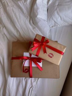 two wrapped presents sitting on top of a bed