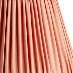 an orange pleated lamp shade on a white background