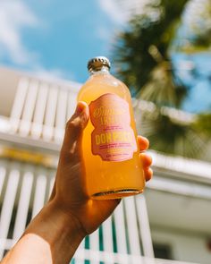 a person holding up a bottle of orange juice