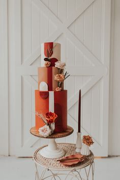 a multi - tiered cake is decorated with flowers and candles