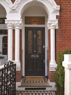 a black front door with white trim and columns