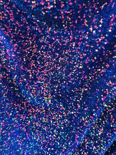 colorful confetti sprinkles are flying in the air on a dark blue background