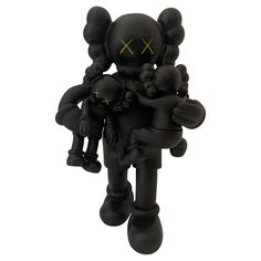 a black and yellow figurine is holding an infant in it's arms