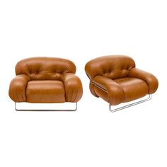 two brown leather chairs sitting next to each other